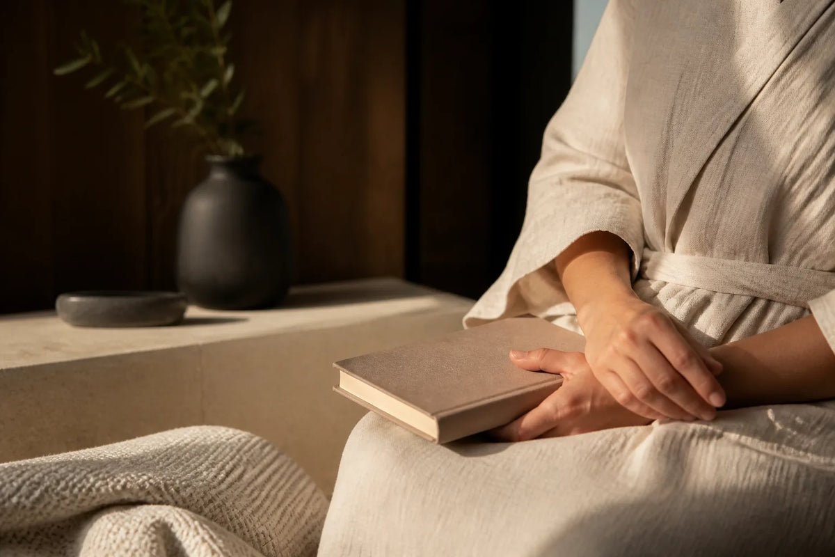 Nero 210X - Sauna intérieur 4-5 places en lumière du soir avec un peignoir et un livre pour la transition vers le repos